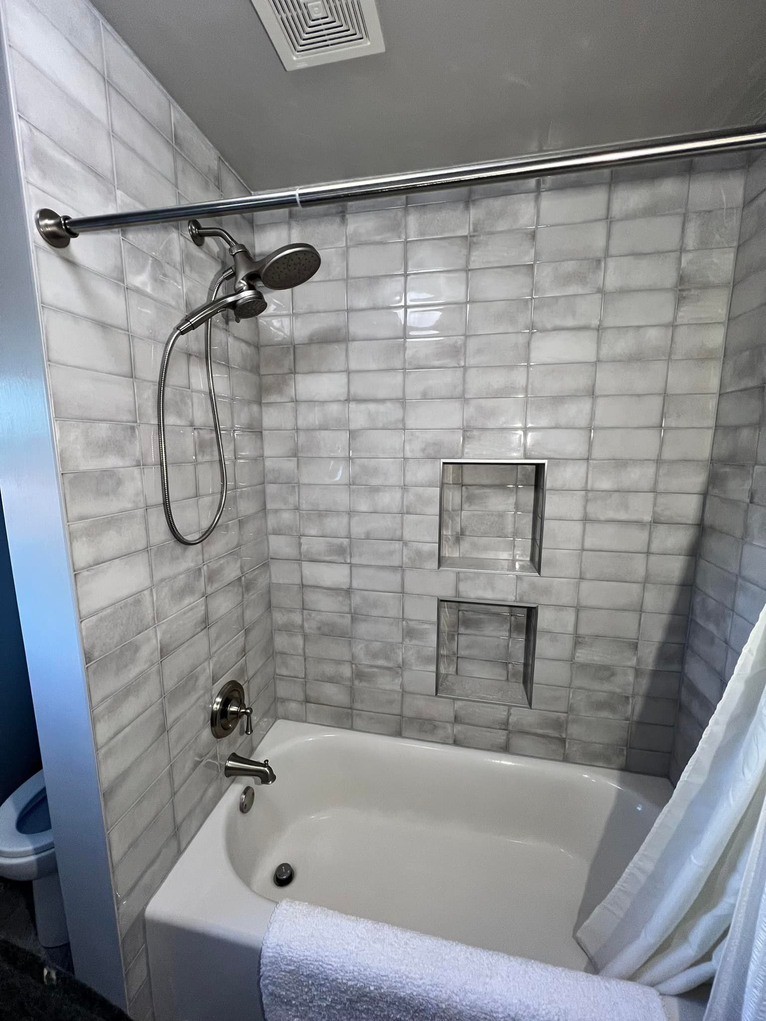 A bathroom with a bathtub and a shower.
