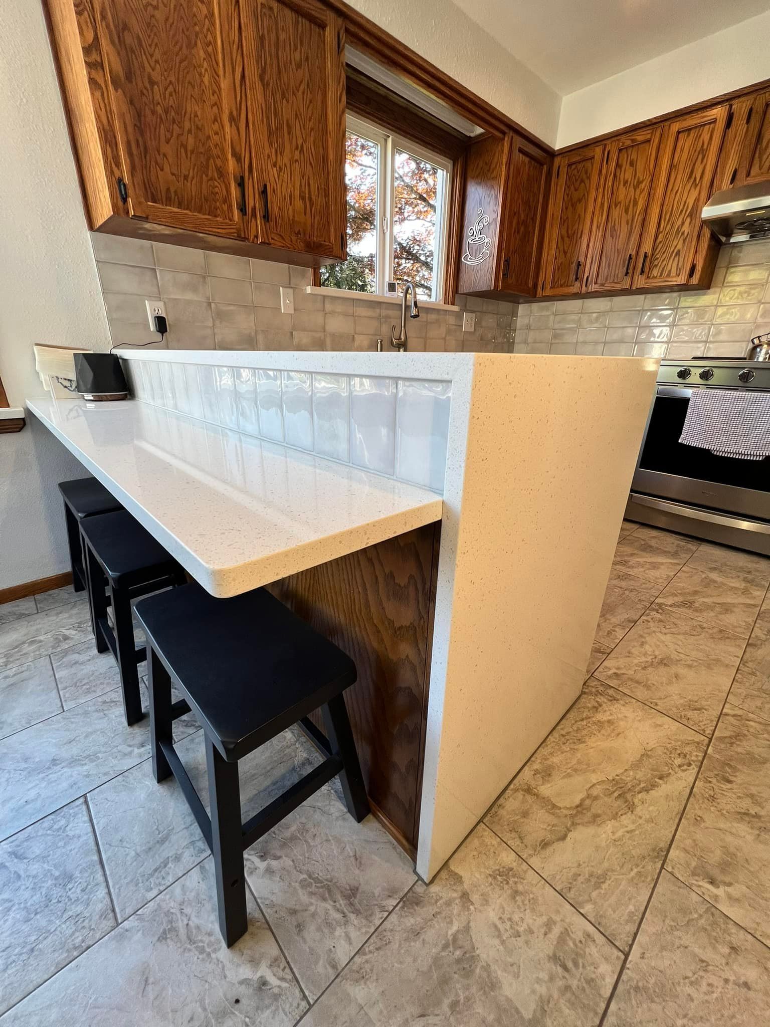 A kitchen with a large island and stools.