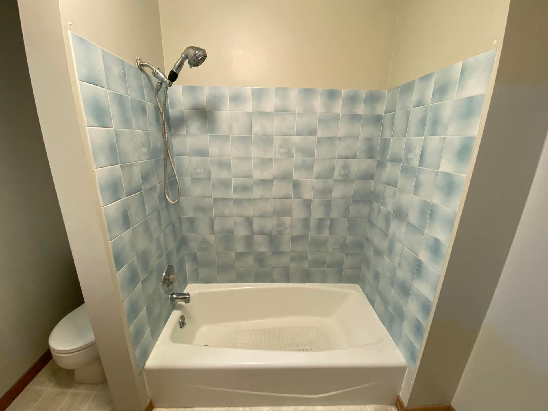 A bathroom with a bathtub , toilet and shower.