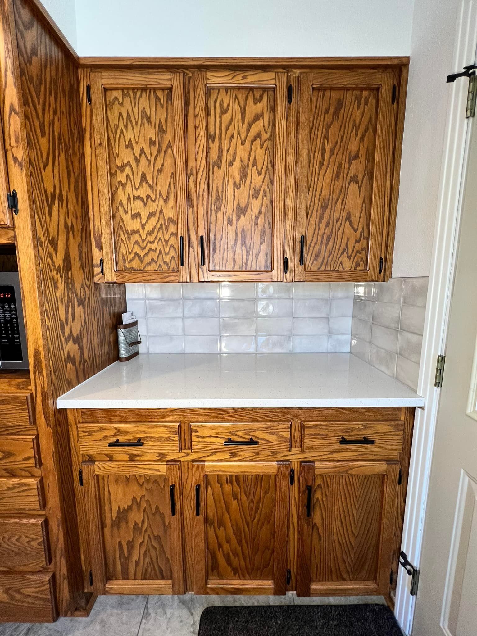 A kitchen with wooden cabinets and a white counter top.