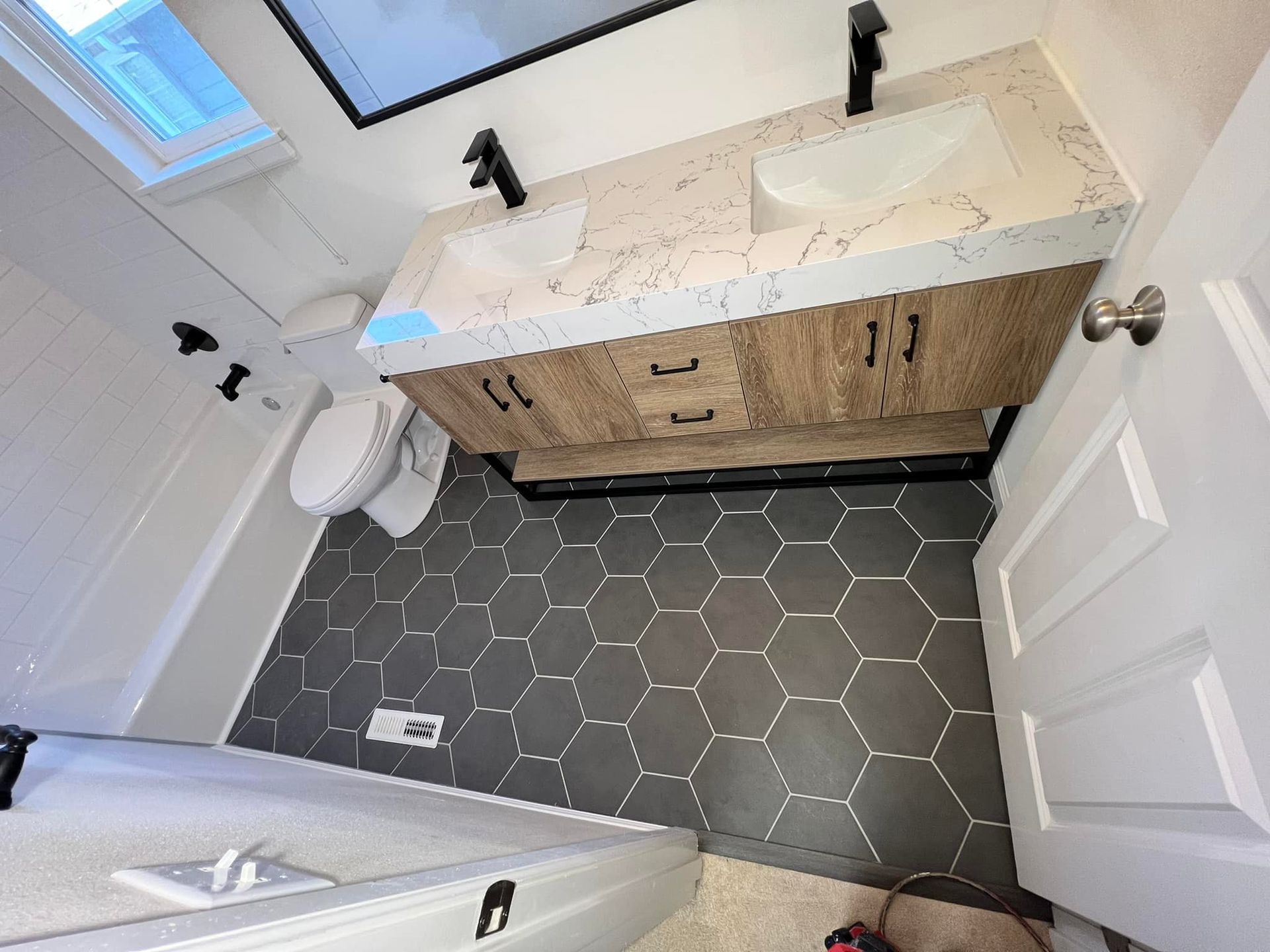 A bathroom with two sinks , a toilet , and a mirror.