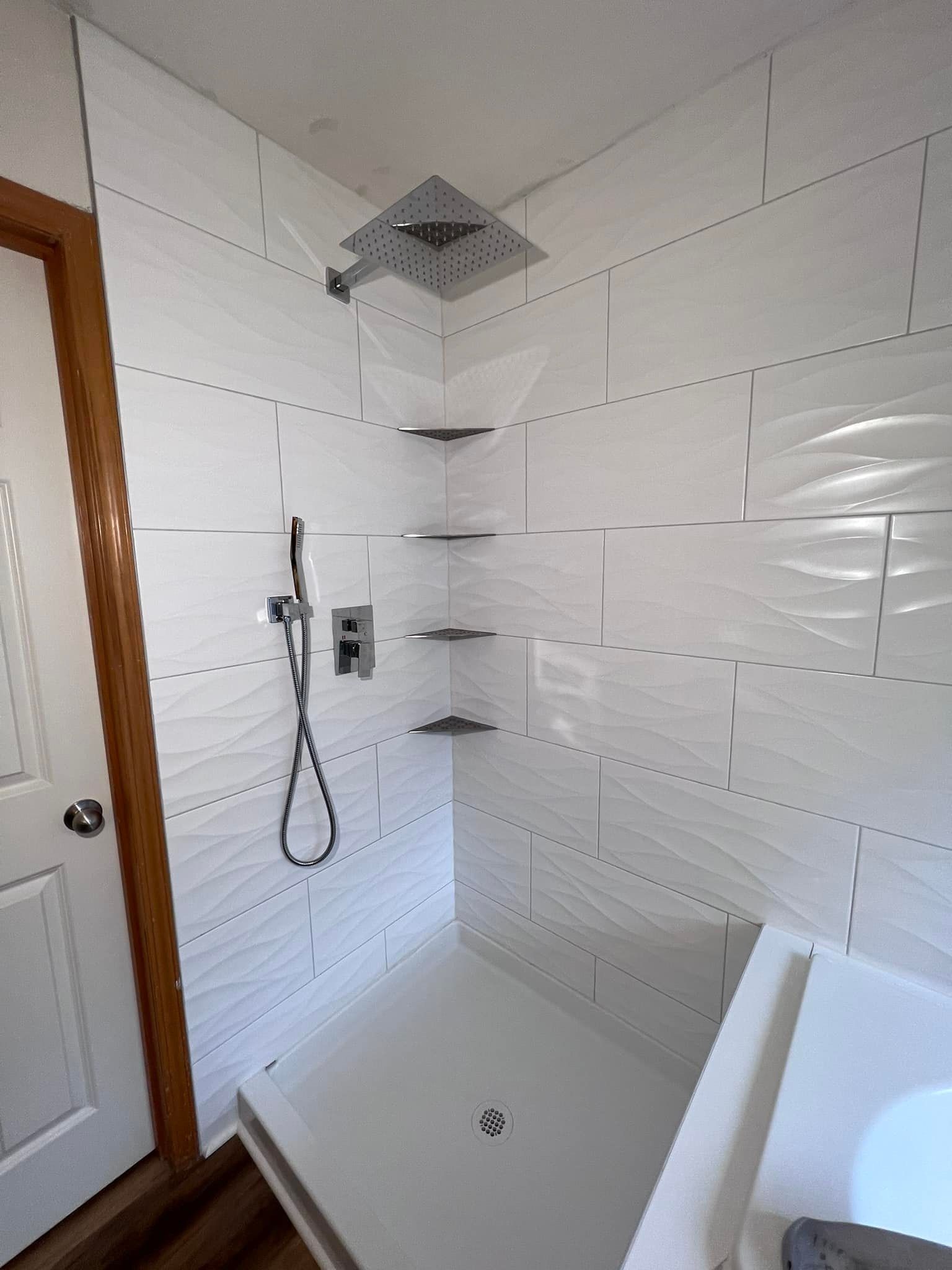 A bathroom with a walk in shower and a tub.