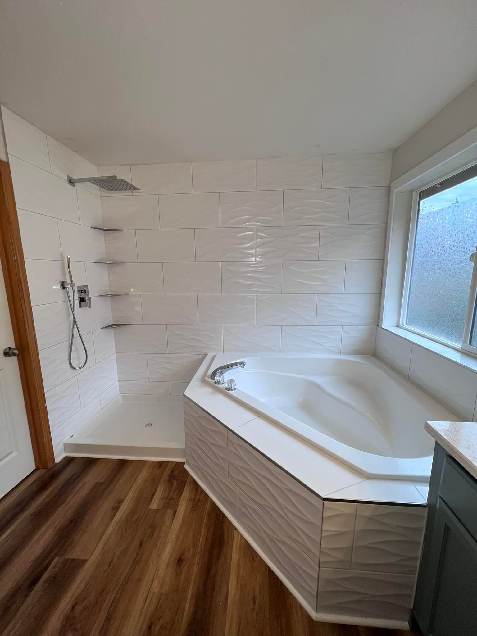 A bathroom with a tub , shower , and window.