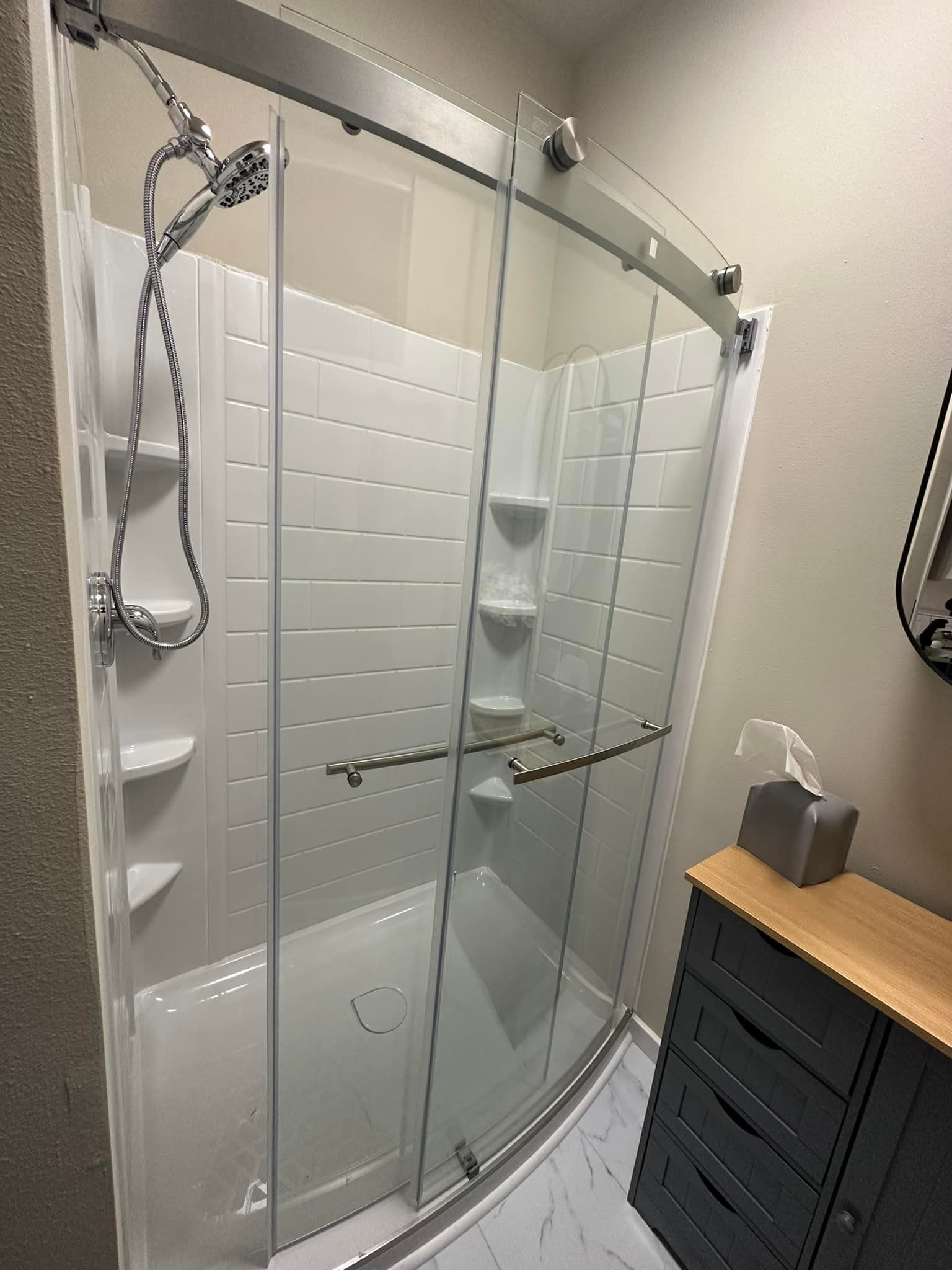 A bathroom with a sliding glass shower door and a bathtub.