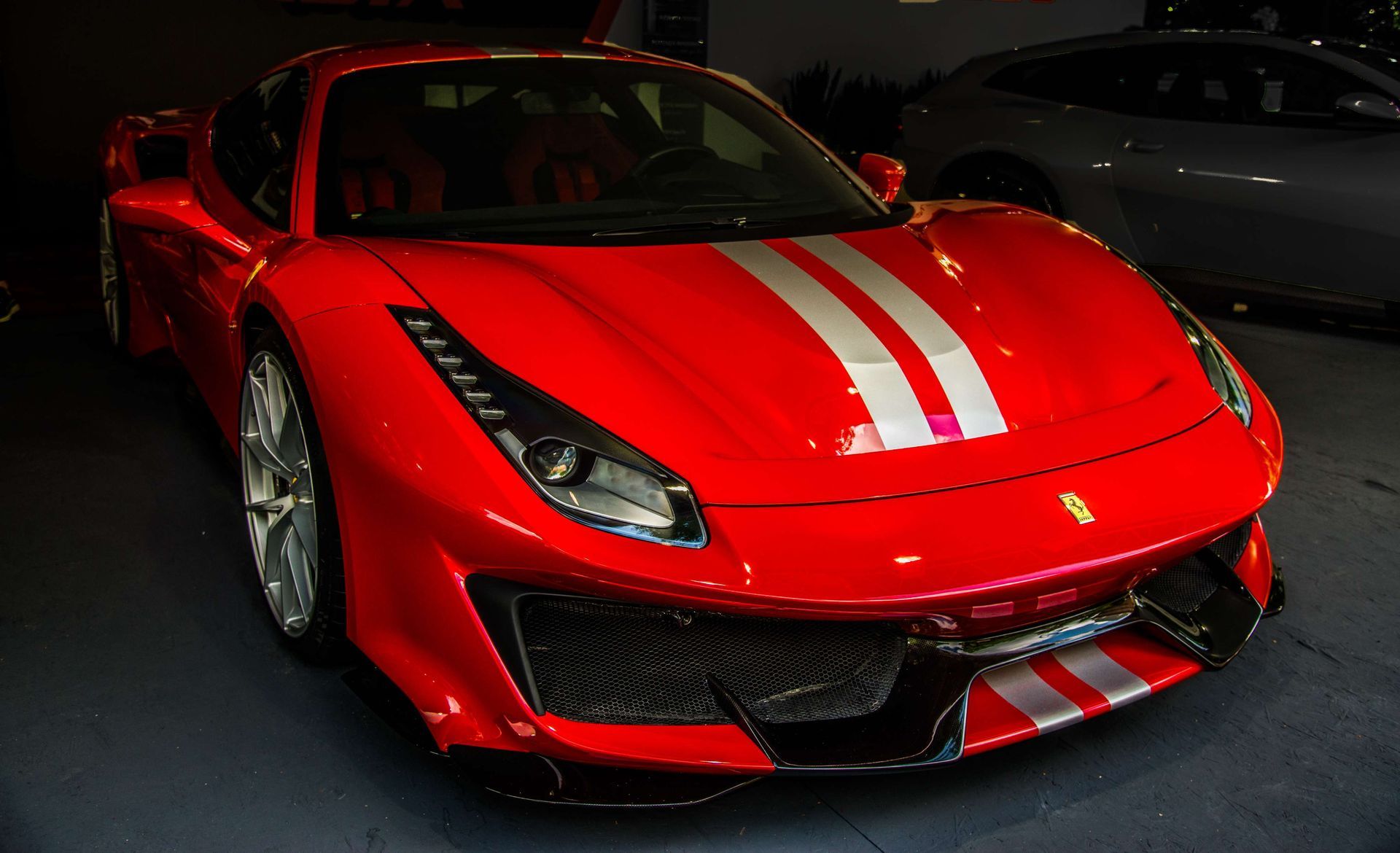 Red Ferrari sports car with silver racing stripes.