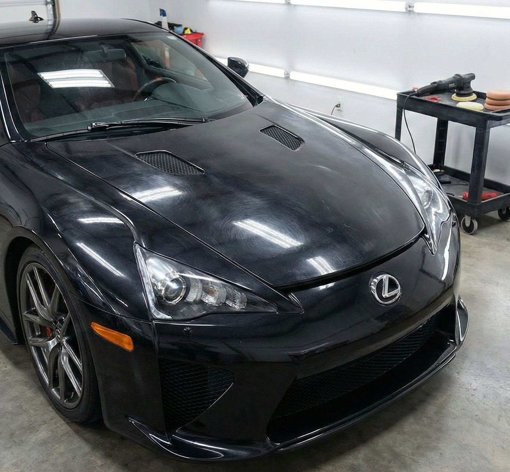 Blue Porsche coupe in a well-lit showroom.
