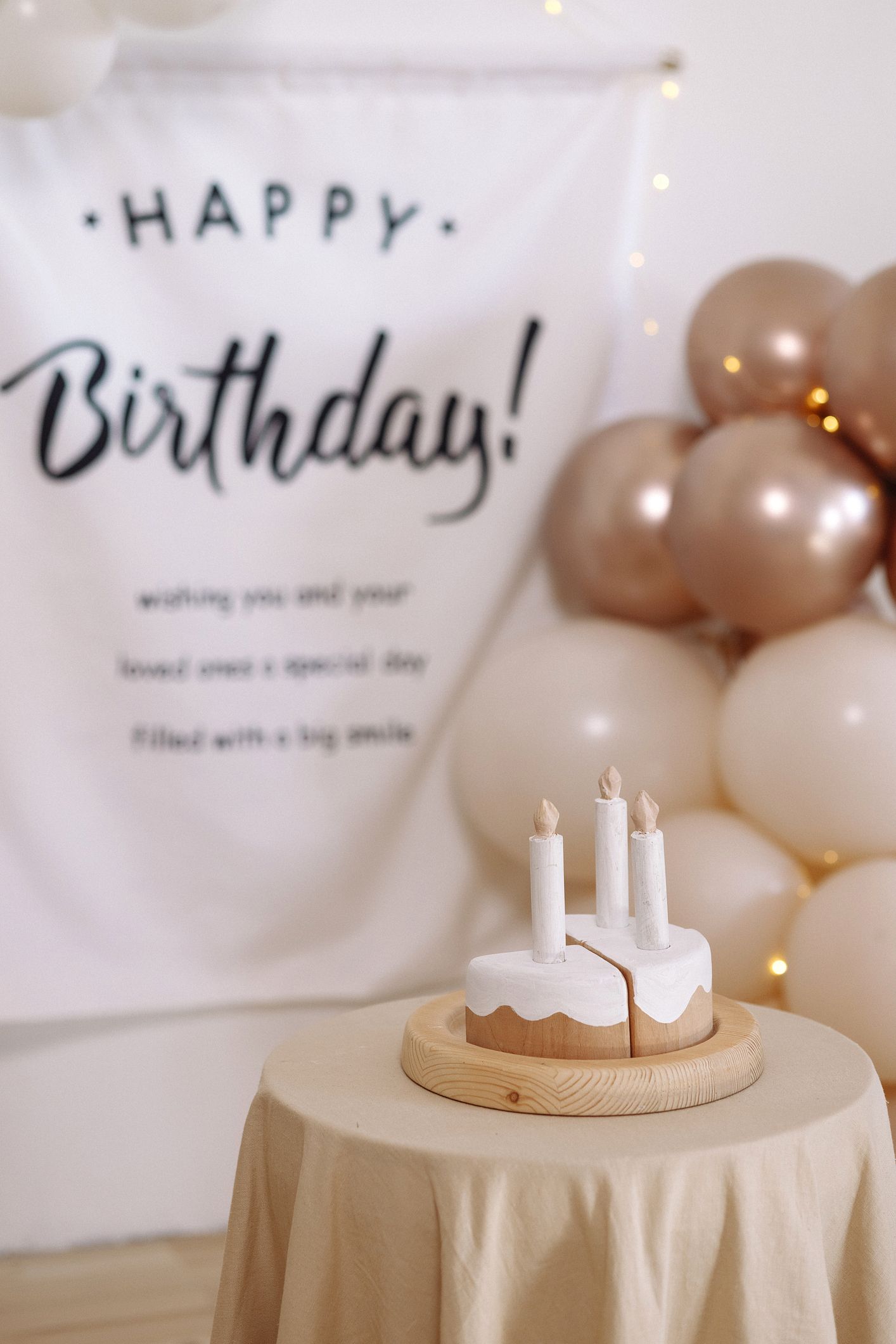 Birthday scene with cake on a table, balloons, and a