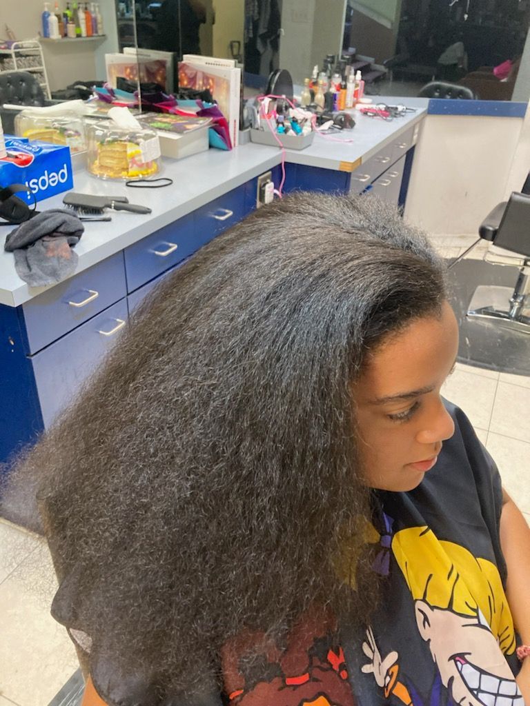 A woman is getting her hair cut in a salon.