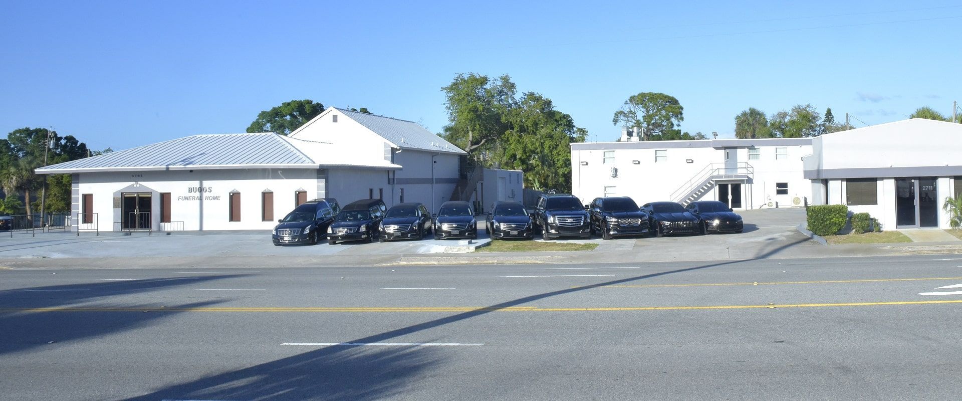 A building with black cars parked in front. "KMC Country Club" is written on the building.