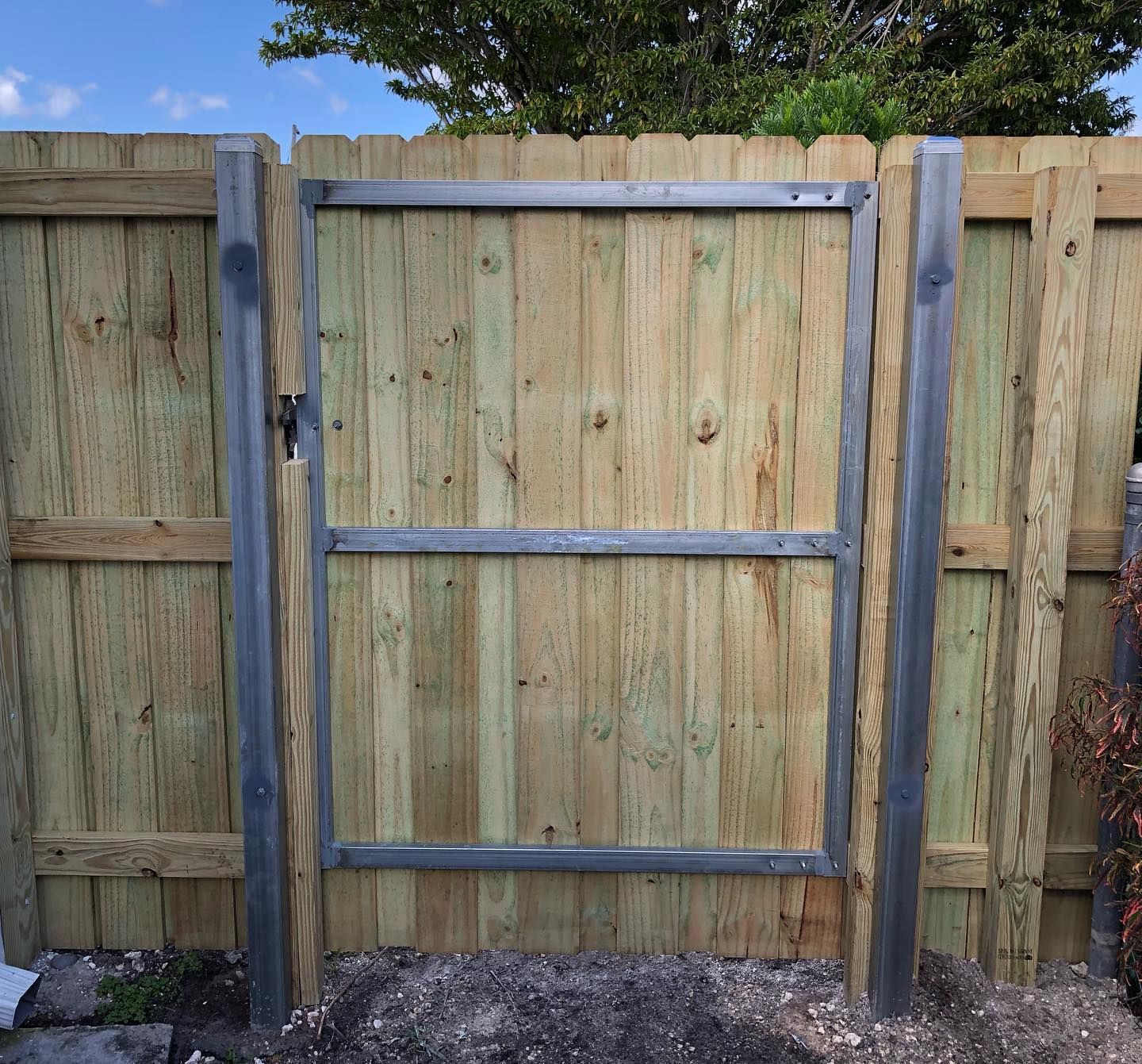 A wooden fence with a metal gate attached to it