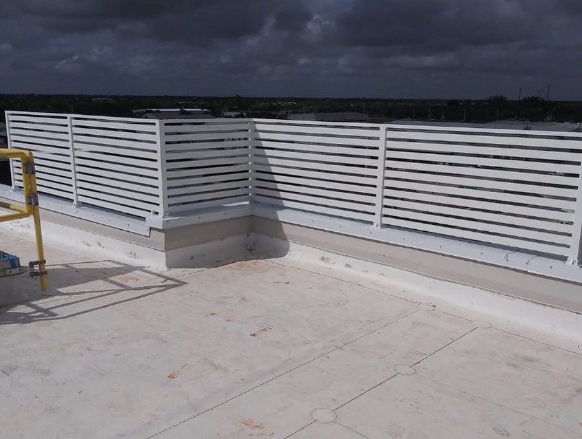 A white fence is sitting on top of a white roof.