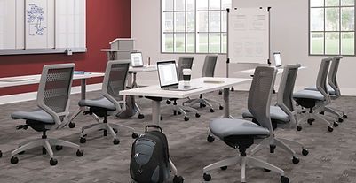 A classroom with tables and chairs and a backpack on the floor.