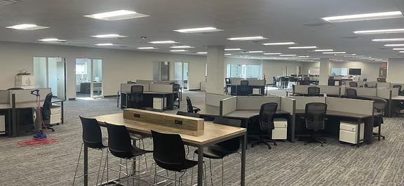 A large empty office with a table and chairs in the middle.