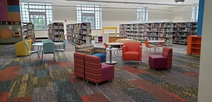 There are many chairs and tables in the library.
