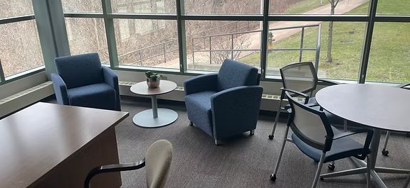 A room with chairs , tables and a large window.