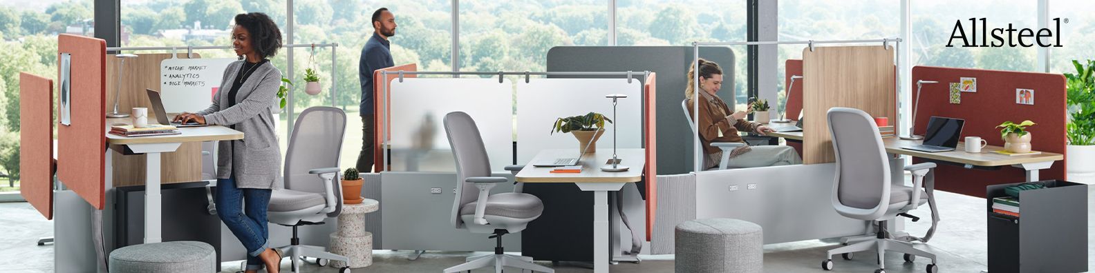 A woman is standing in front of a desk in an office.