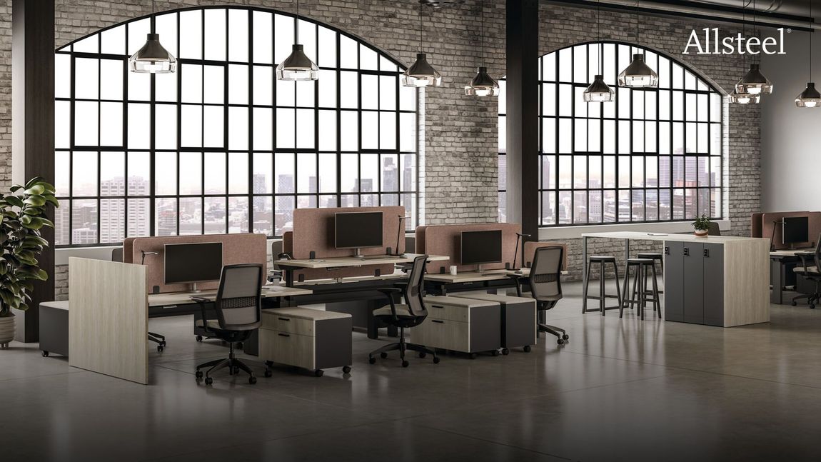 An office with a lot of desks and chairs and a lot of windows.