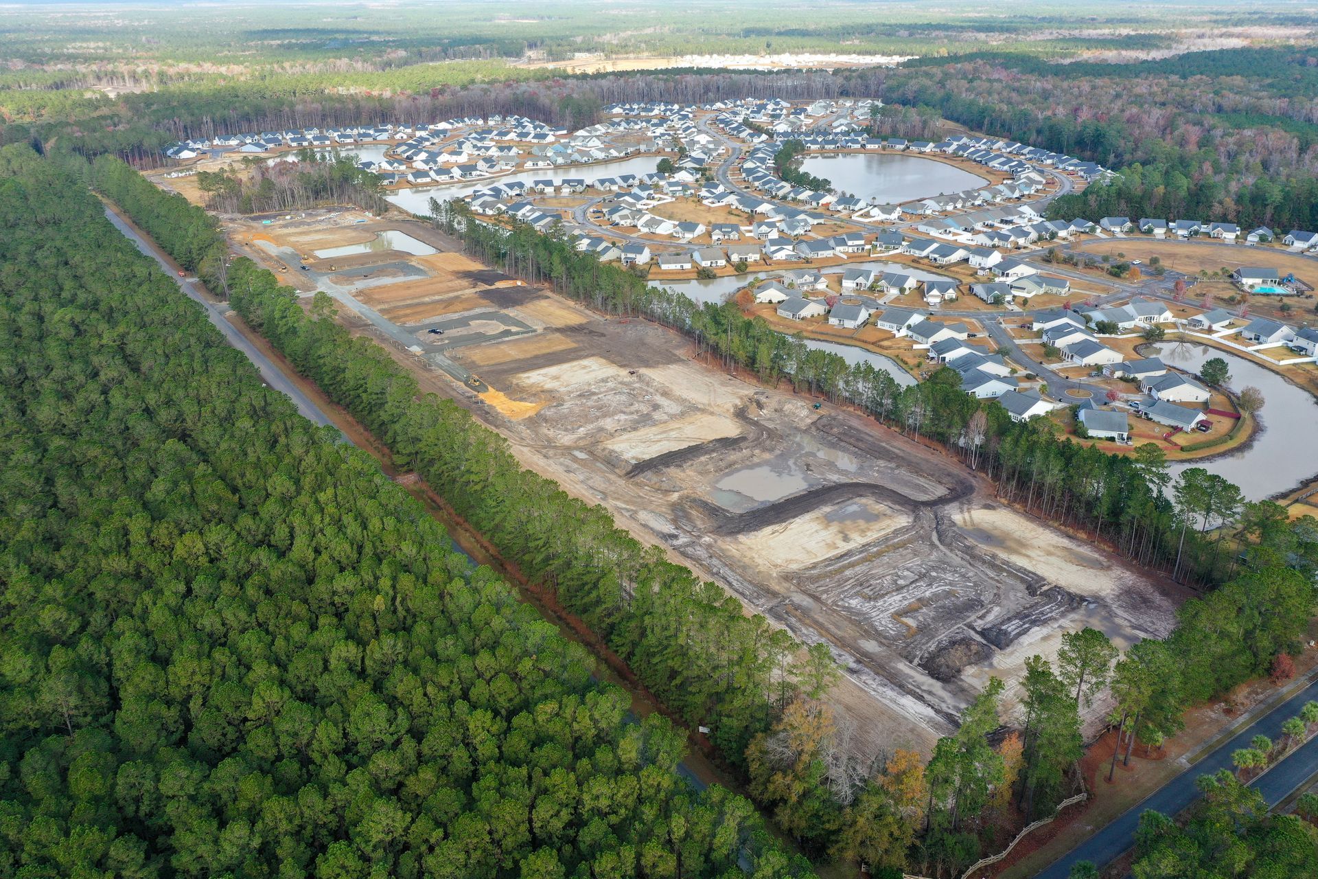 An aerial view of a residential area surrounded by trees and a river.