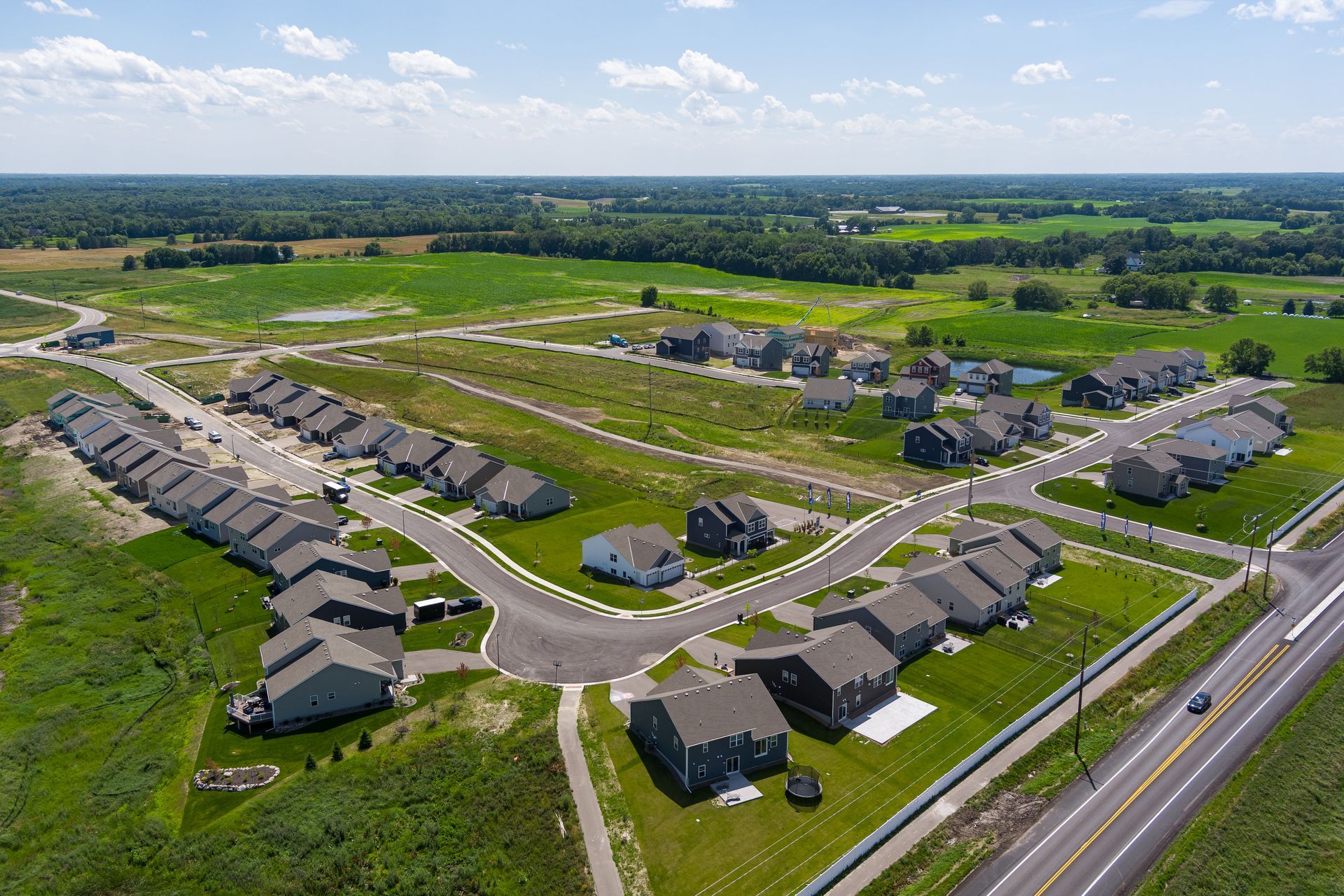 An aerial view of a residential area with lots of houses and a highway.