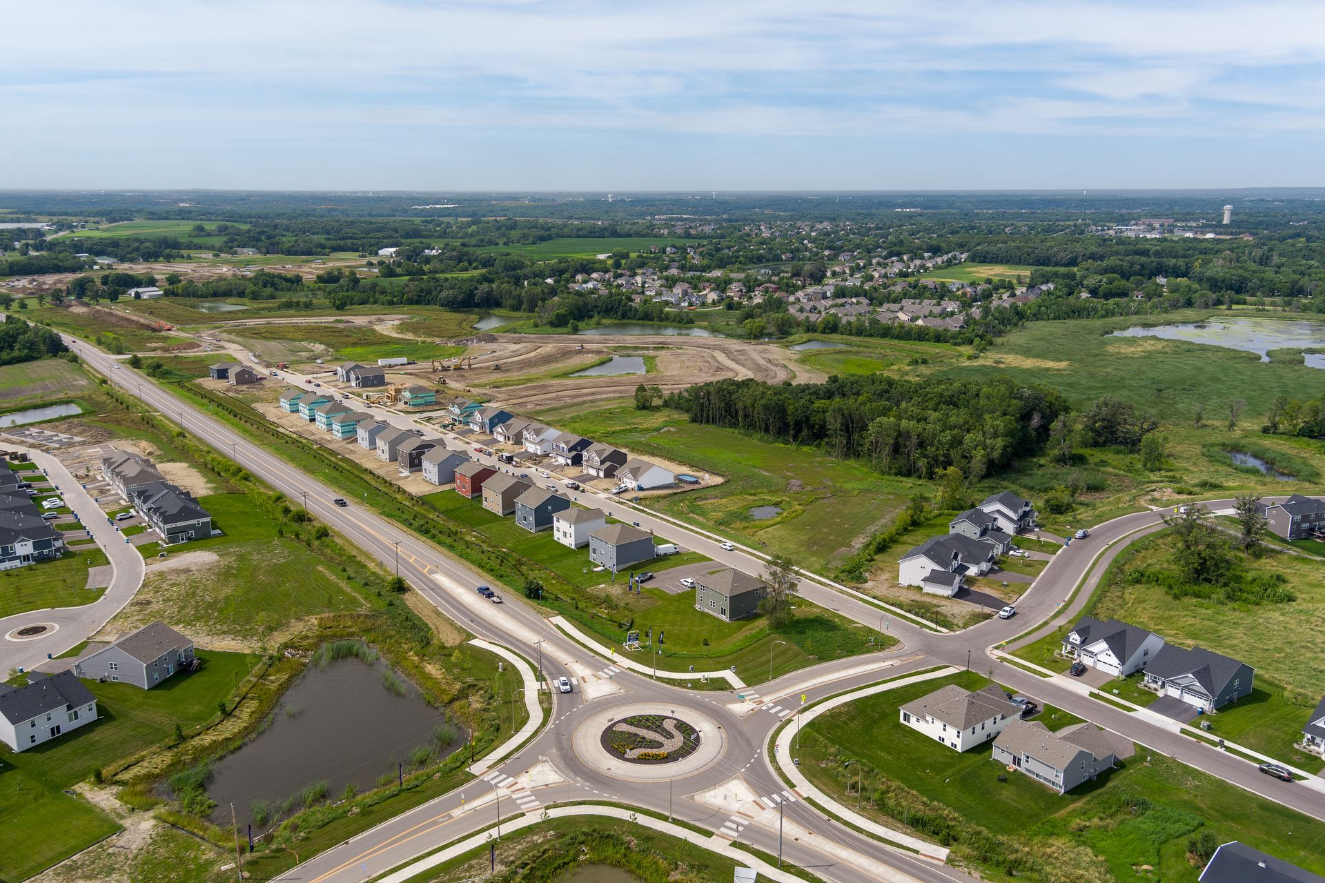 An aerial view of a residential area with a roundabout in the middle.