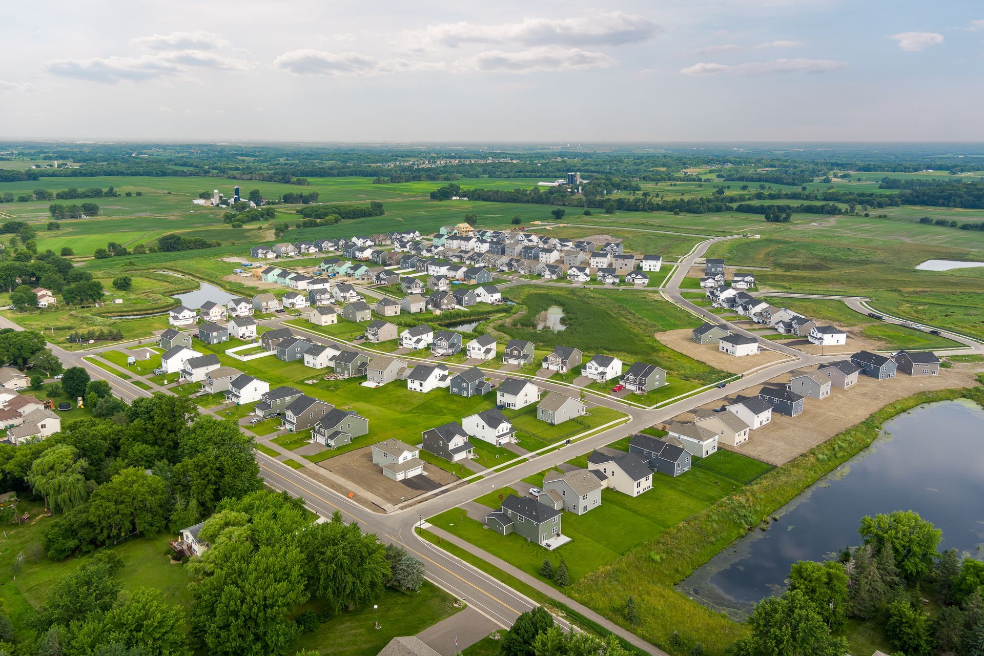 An aerial view of a residential neighborhood with a lake in the middle of it.
