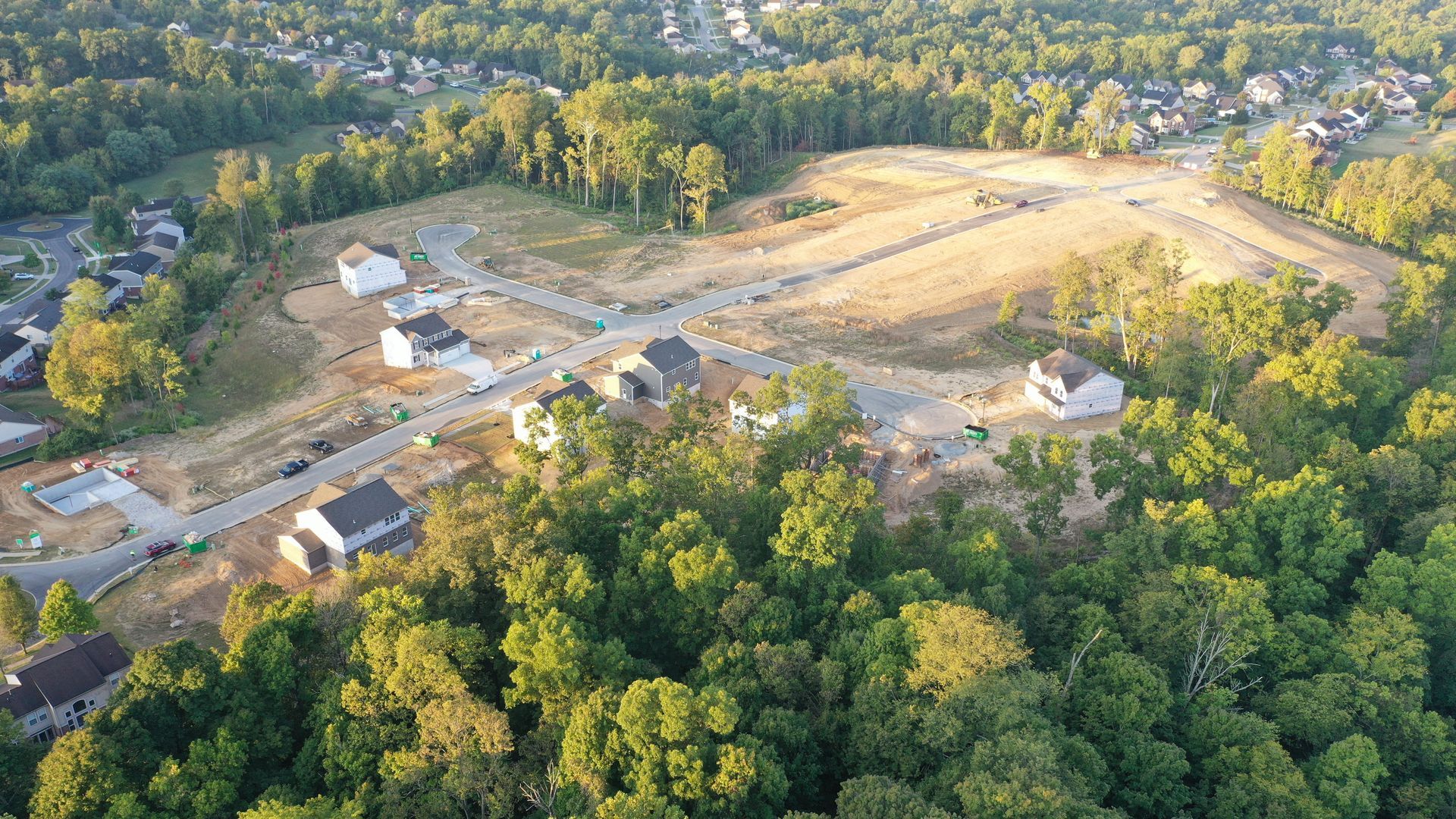 tamarack development project An aerial view of a residential area surrounded by trees and houses.
