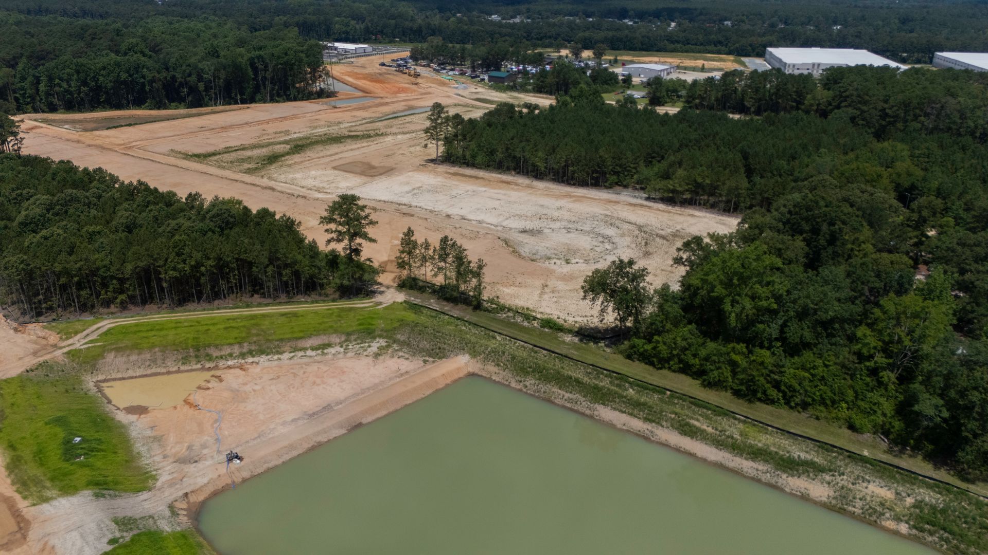 A group of tractors are working on a dirt field.