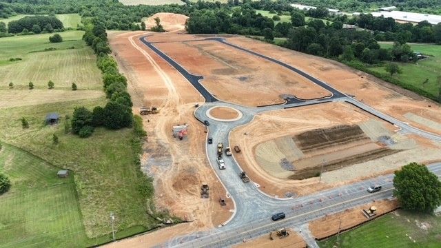 An aerial view of a construction site with a roundabout in the middle of it.