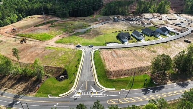 An aerial view of a residential area with a road going through it.