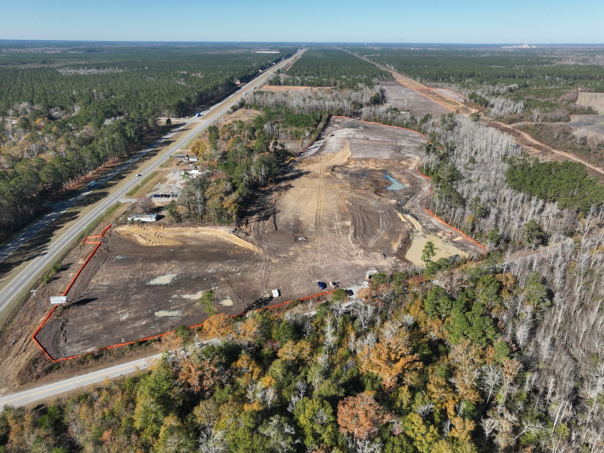 An aerial view of a road going through a forest.