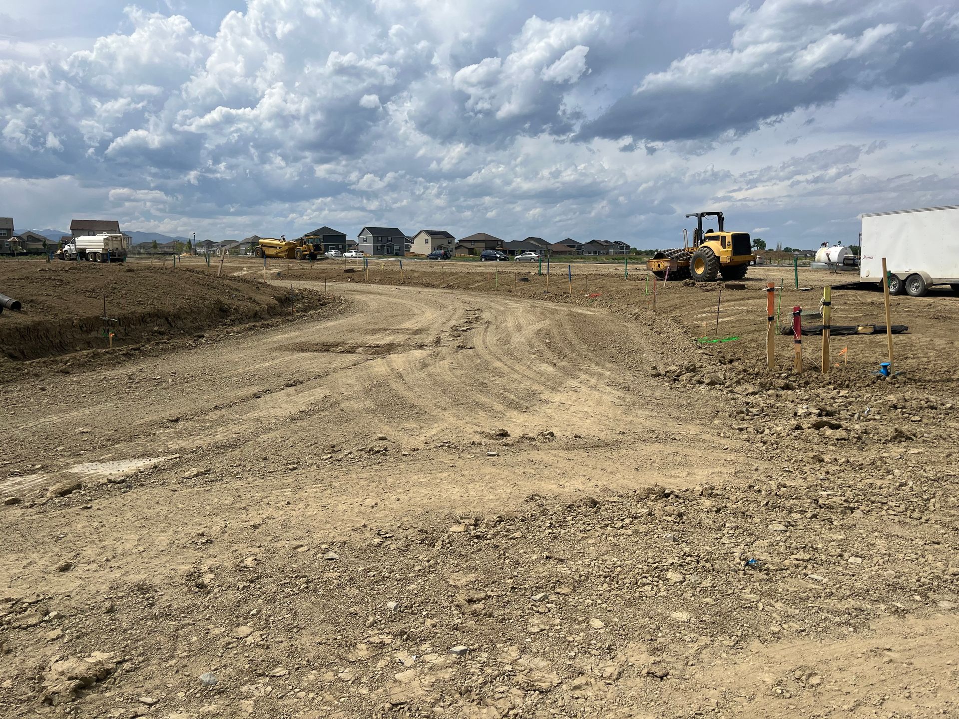 A construction site with a lot of dirt and a tractor in the background.