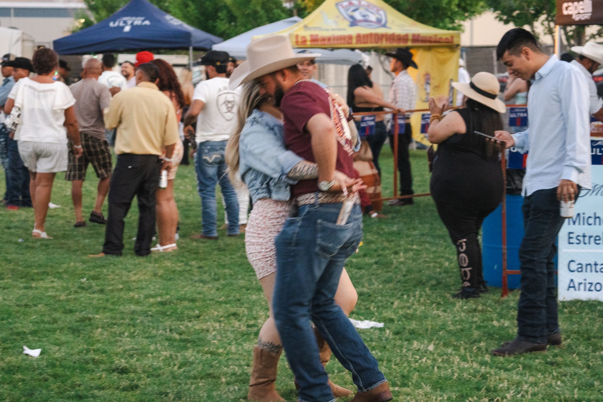 A man and a woman are hugging each other in front of a crowd of people.