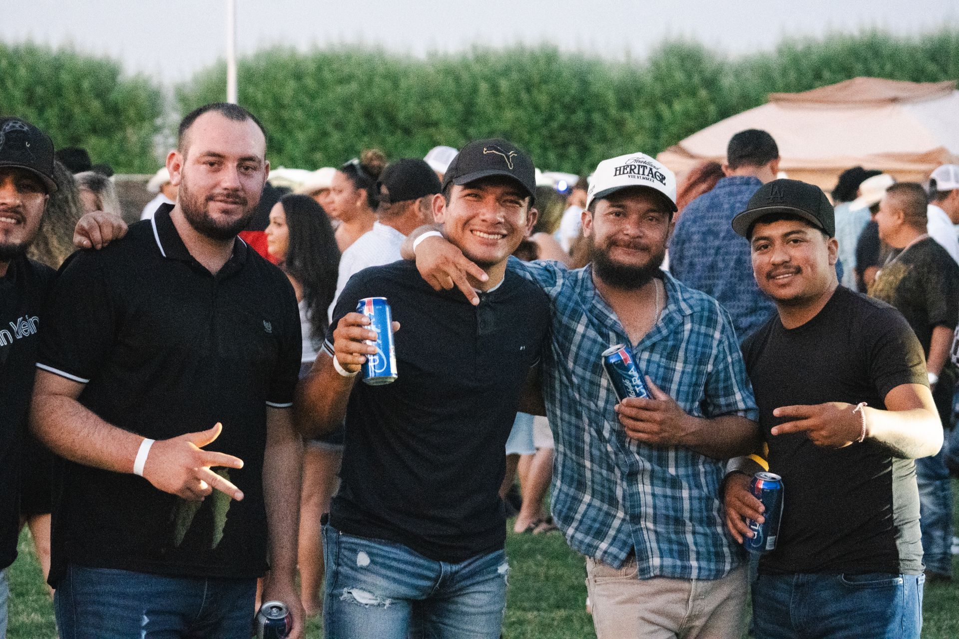 A group of men are posing for a picture while drinking beer.