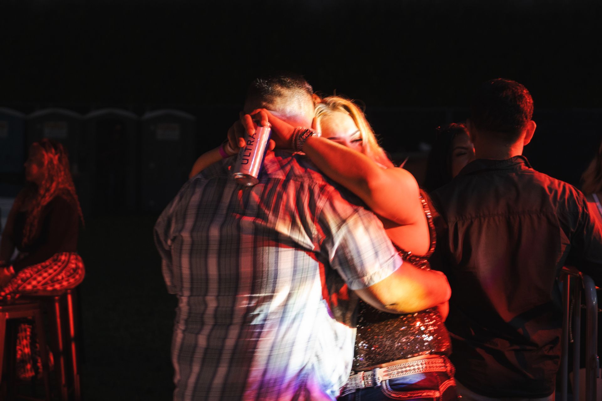 A man and a woman are dancing in a dark room.