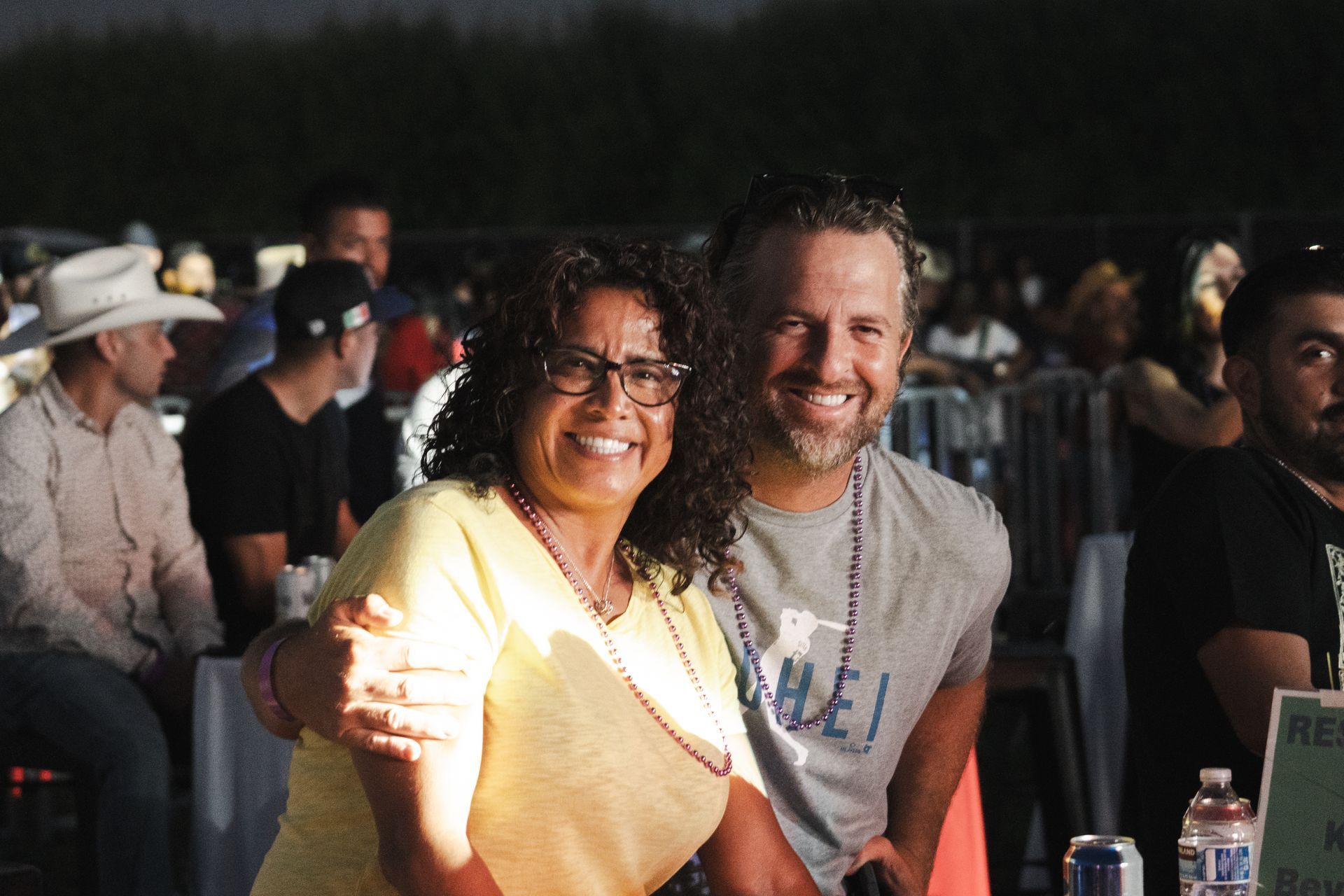 A man and a woman are posing for a picture at a concert.