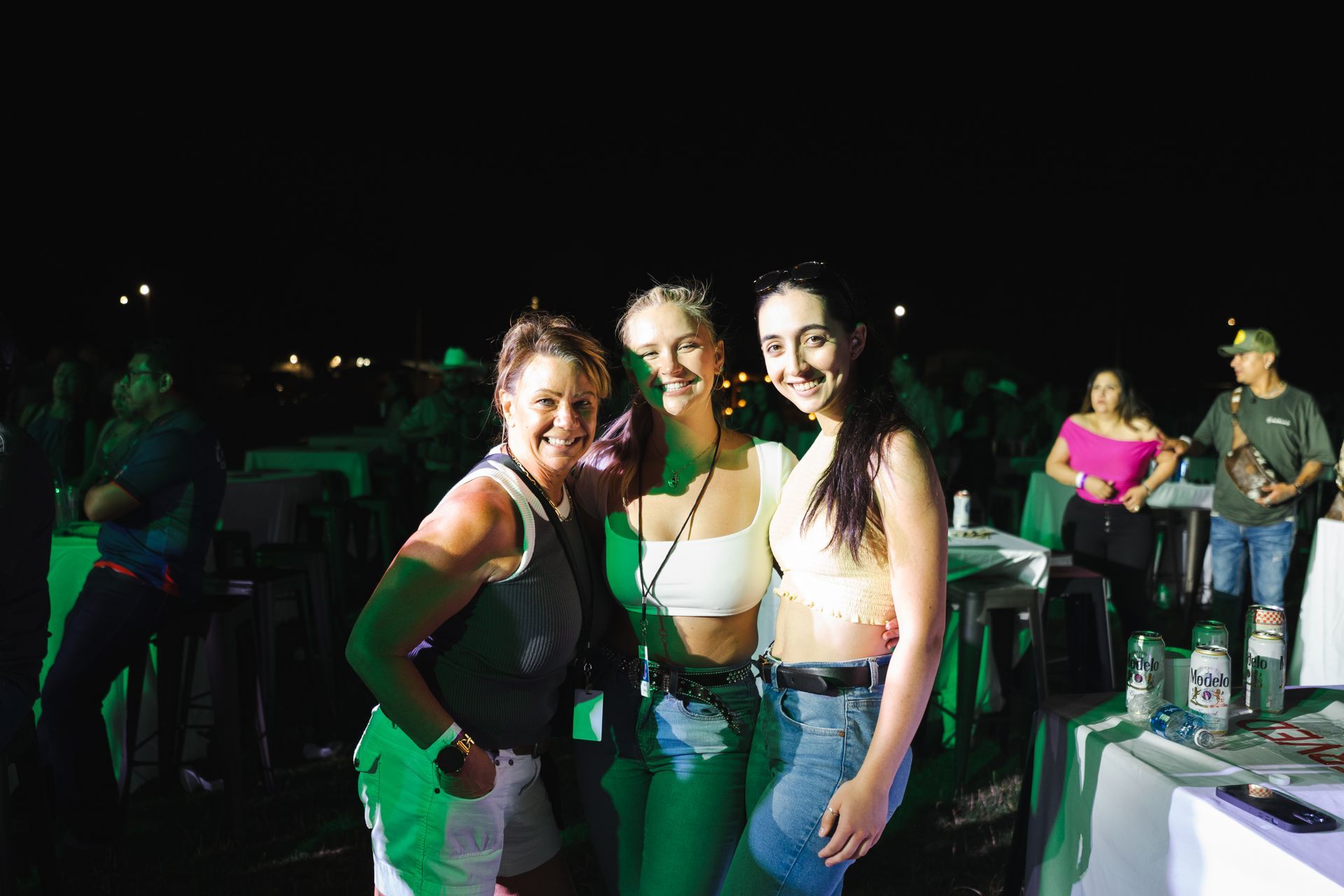 Three women are posing for a picture at a party.