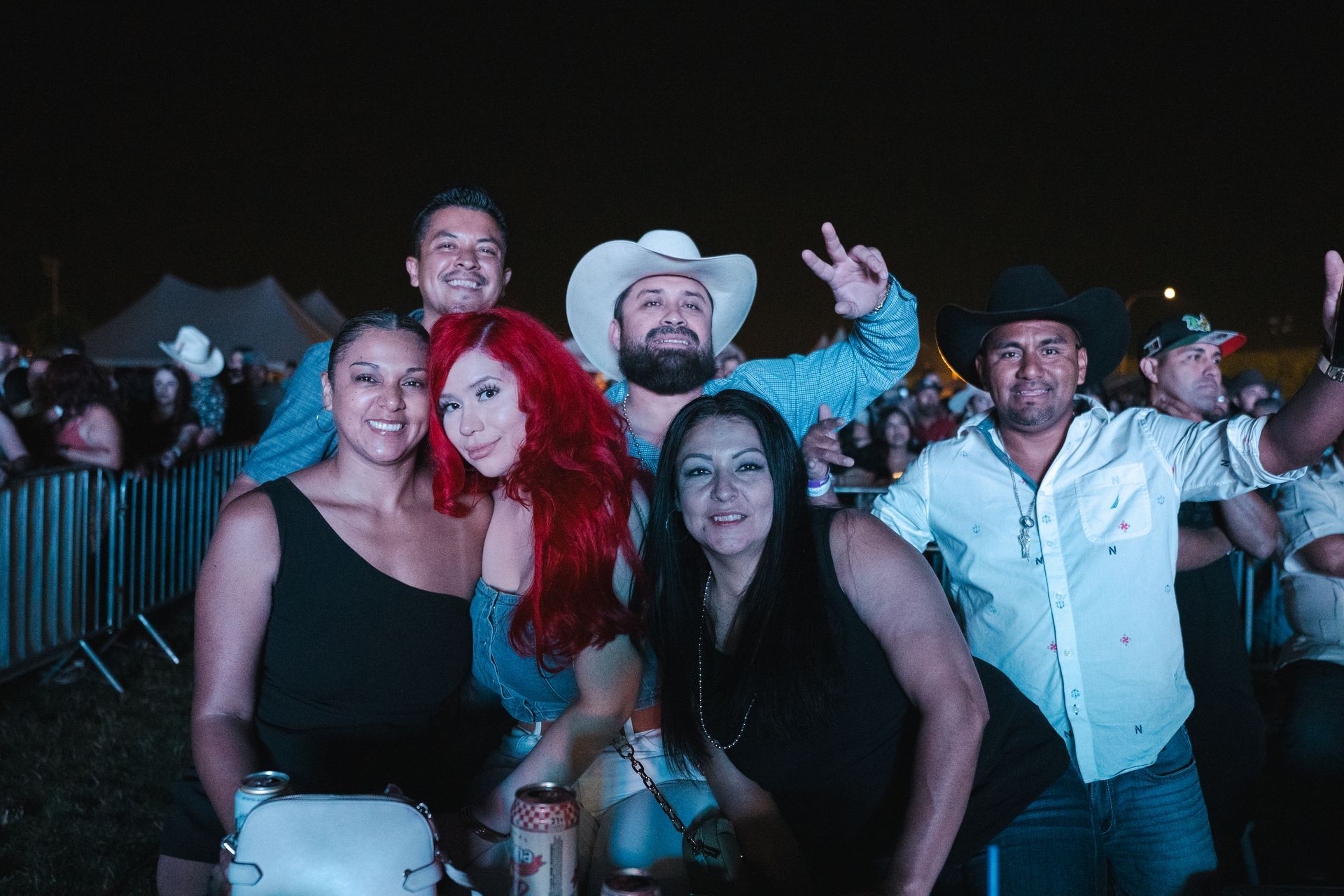A group of people are posing for a picture at a concert.