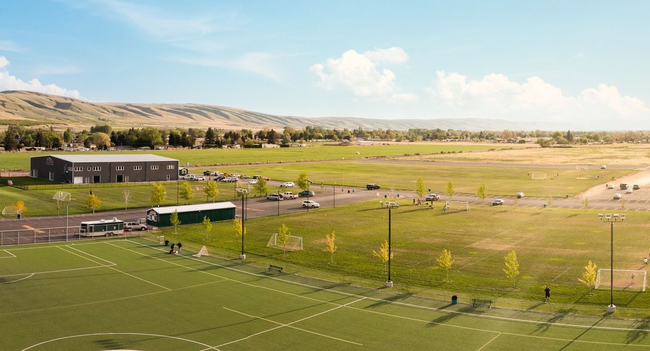 An aerial view of a football field with a building in the background.