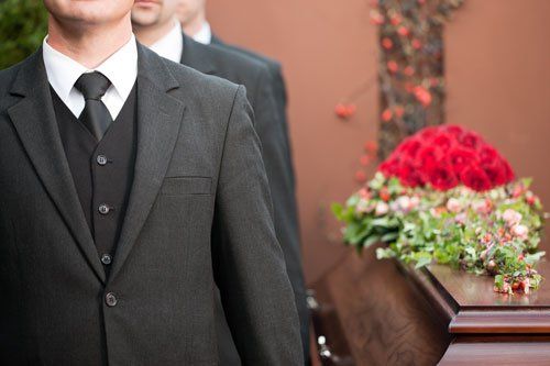 uomini in giacca e cravatta ad un funerale