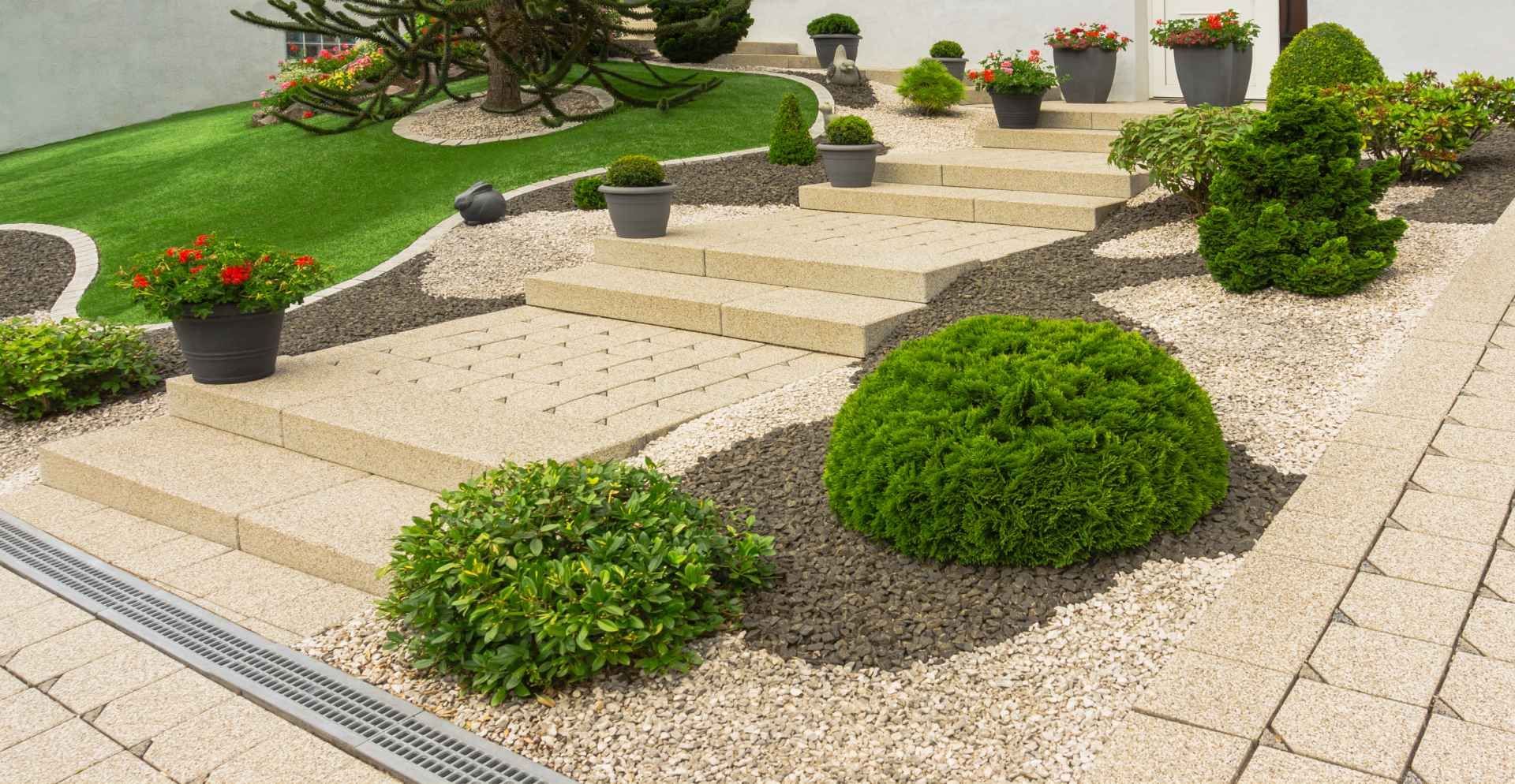 A garden with stairs , plants , and potted plants.