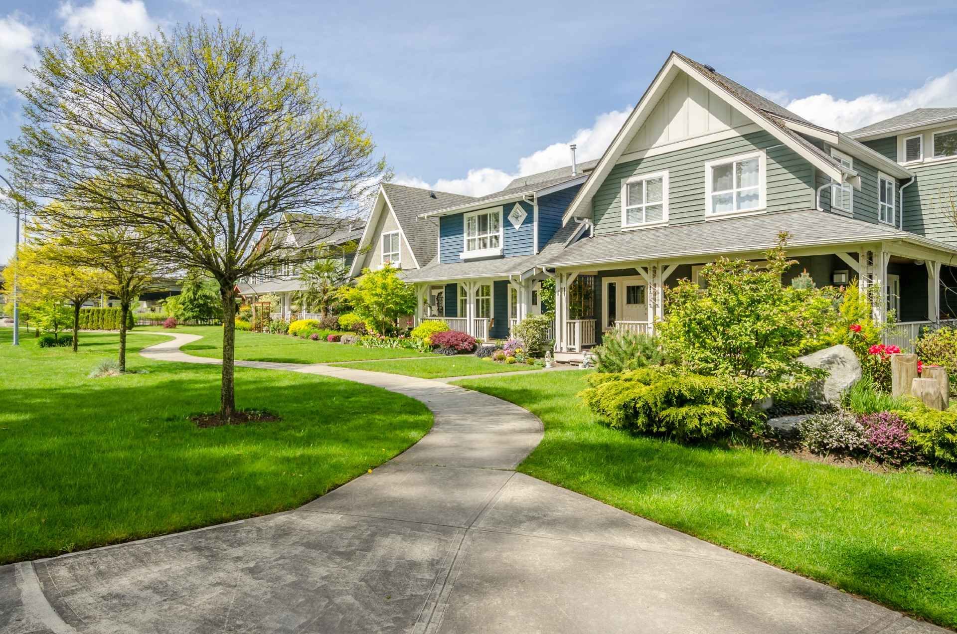 A row of houses sitting next to each other on a lush green lawn.