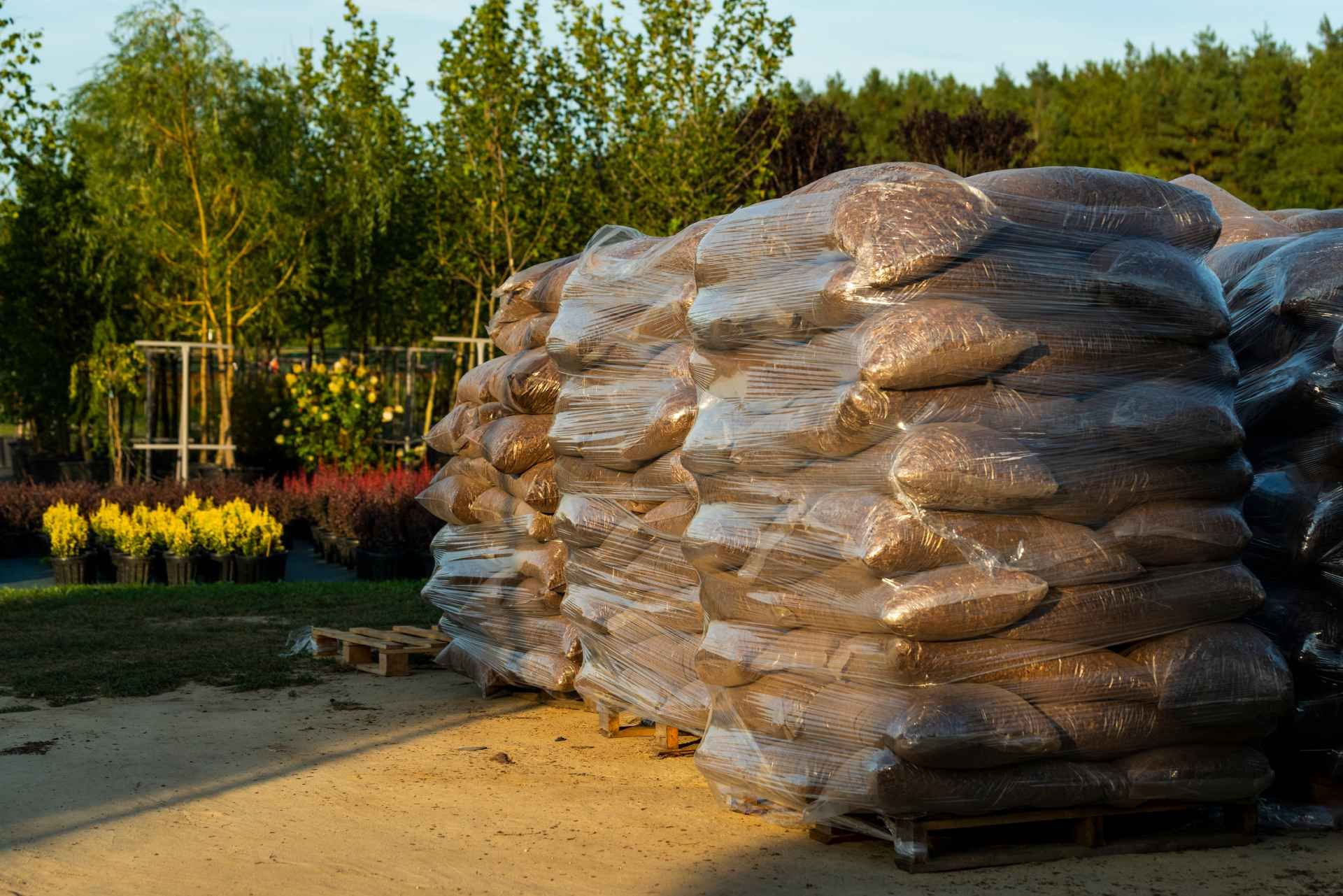 A pile of bags sitting on top of each other on a dirt road.