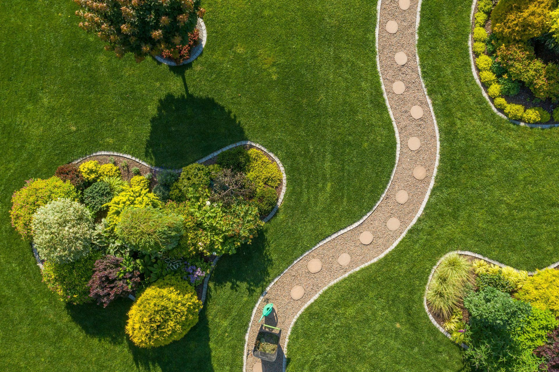 An aerial view of a person walking down a path in a garden.