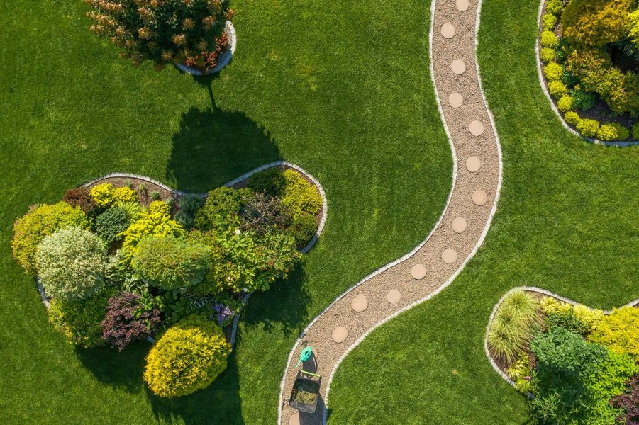 An aerial view of a person walking down a path in a garden.