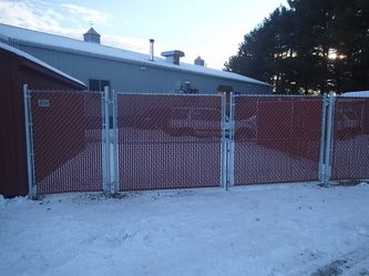 A Chain Link Fence With Snow in Front of a Building – Pittsfield, MA - New England Fence