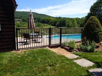 A Metal Fence Surrounds a Swimming Pool – Pittsfield, MA - New England Fence