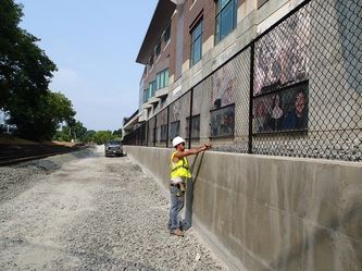 A Man is Standing Next to a Chain Link Fence – Pittsfield, MA - New England Fence