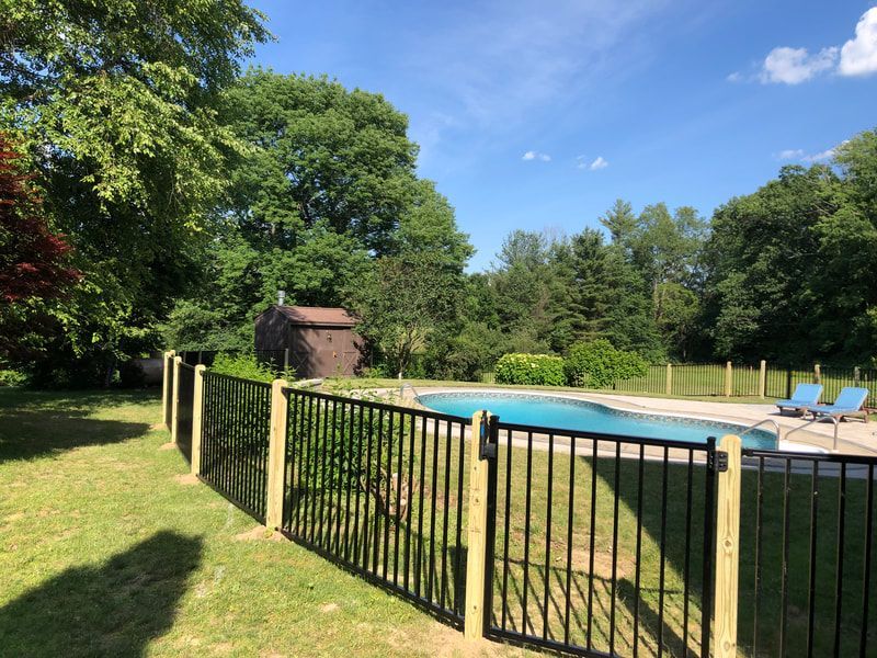 A Metal Fence Surrounds a Large Swimming Pool – Pittsfield, MA - New England Fence