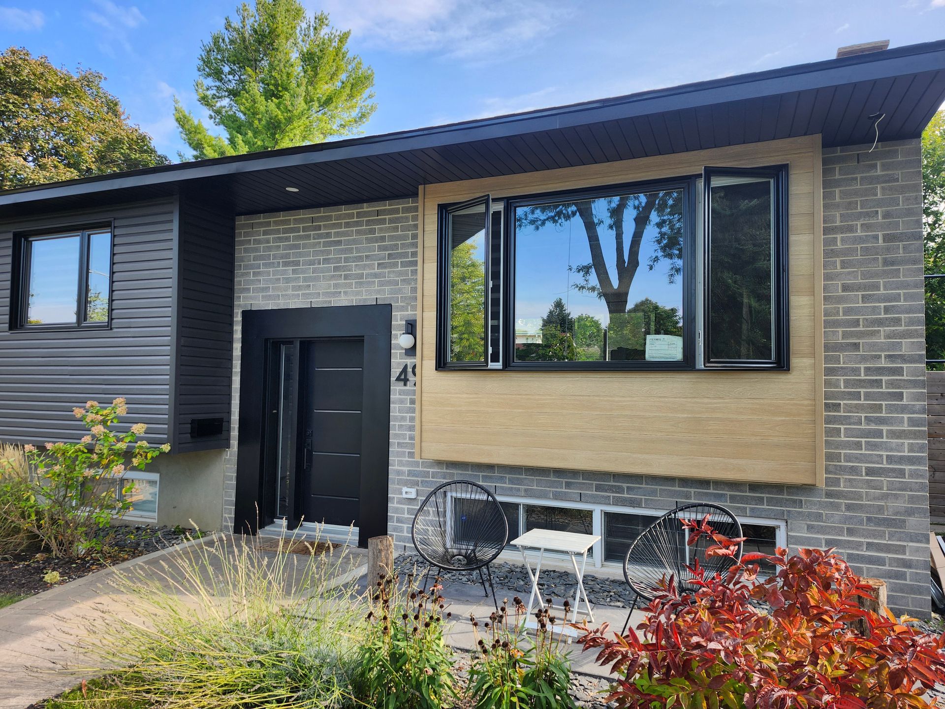 Une cuisine avec armoires en bois, comptoirs noirs, appareils électroménagers en acier inoxydable et un livre sur le comptoir.