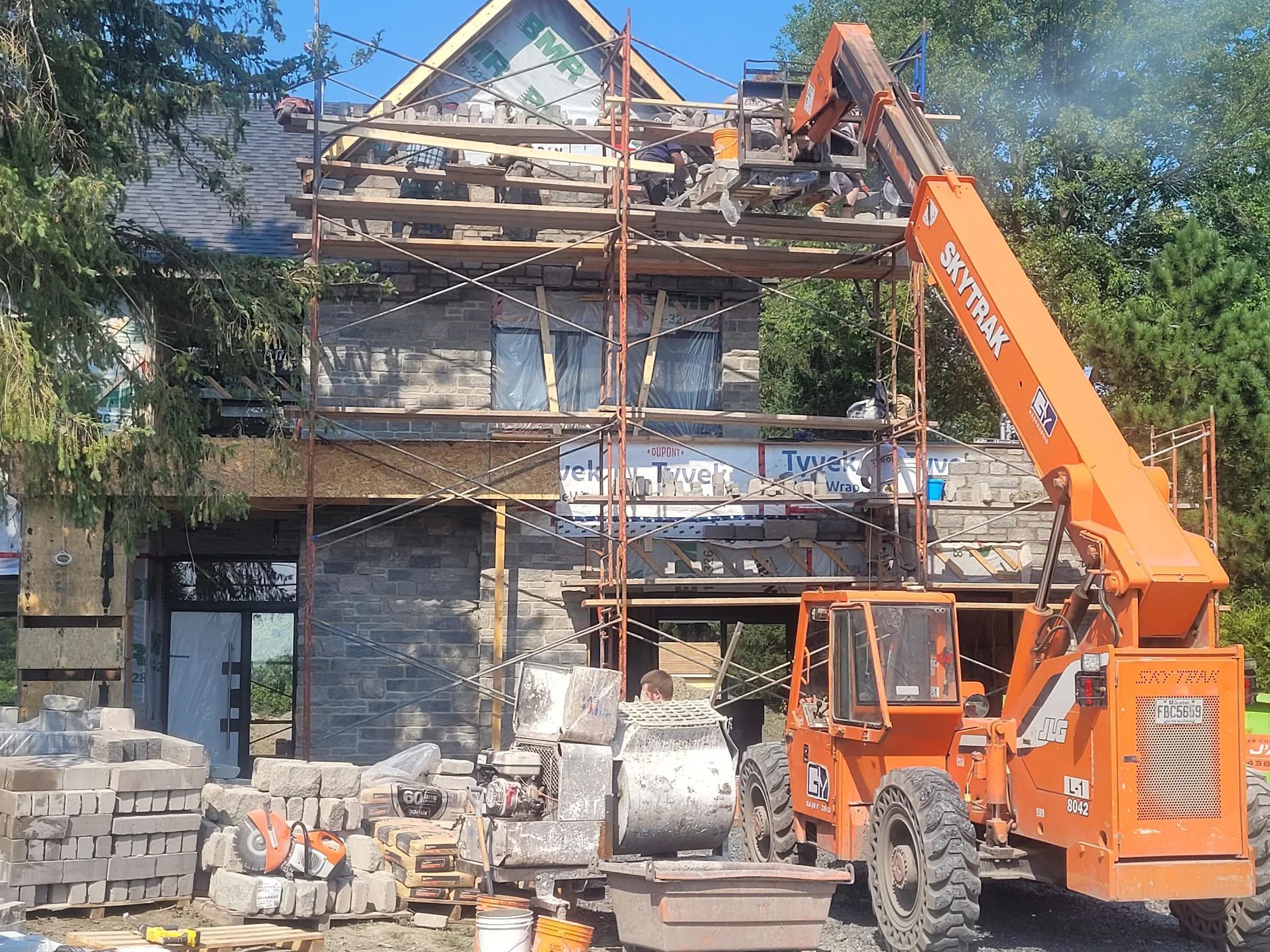 Une grande grue orange est garée devant une maison en construction